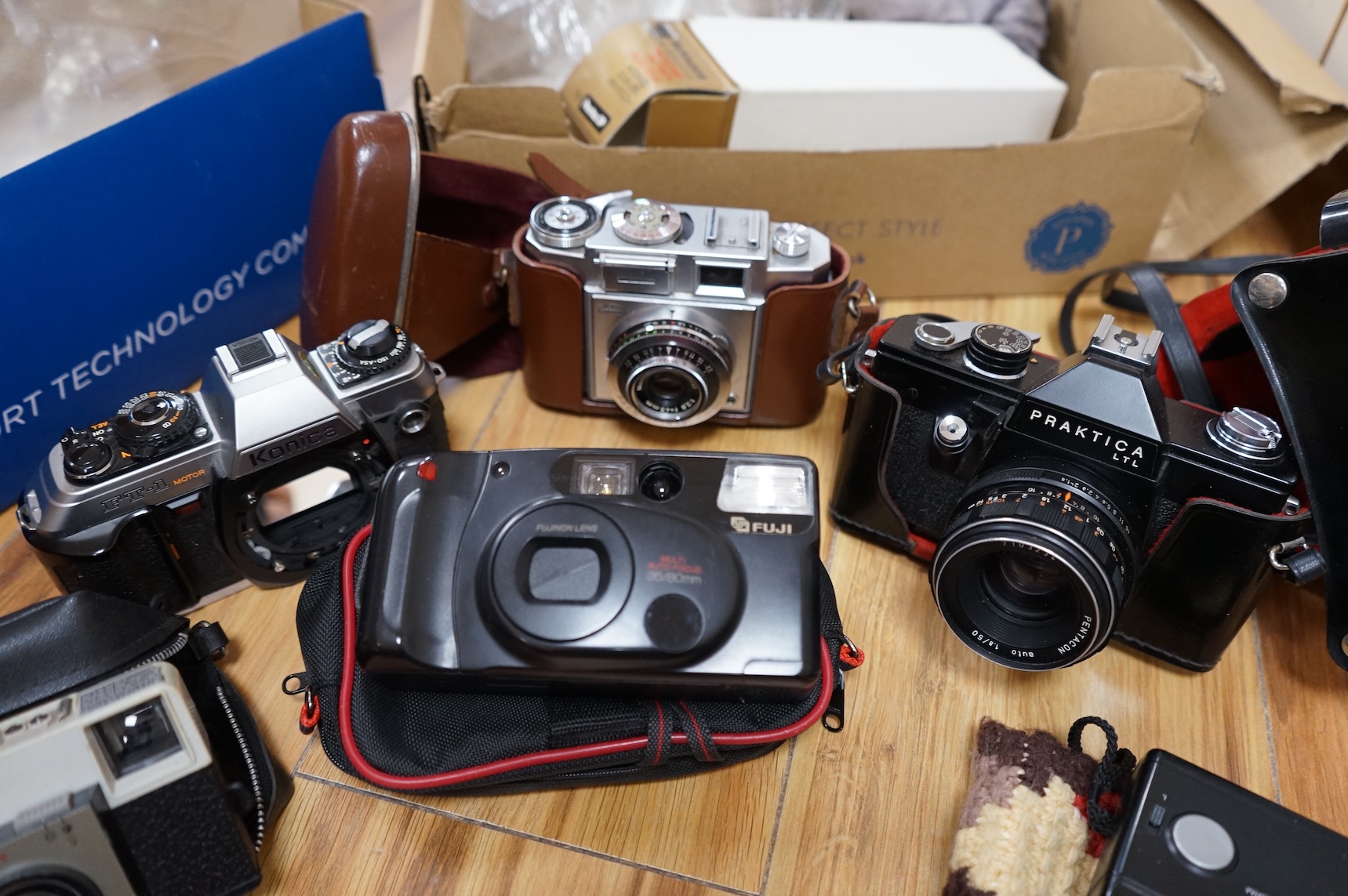 A collection of various cameras and camera equipment to include Konica